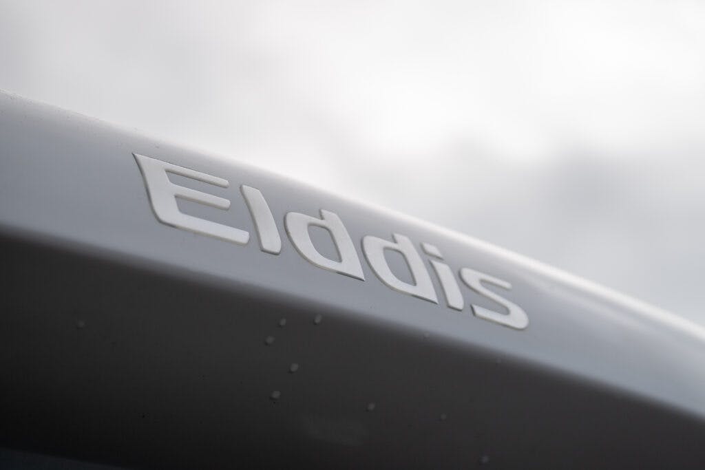 Close-up view of the "Elddis" logo on the side of a 2019 Elddis Autoquest 196 Signature Edition vehicle, with a blurred sky in the background.