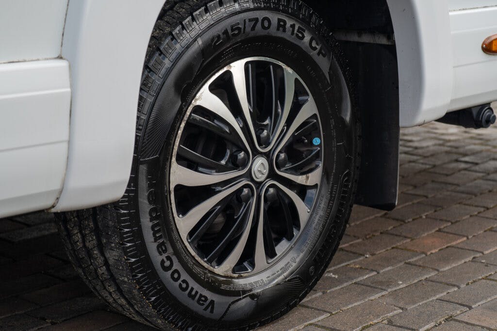 Close-up photo of a car tire mounted on a shiny, black and silver rim. The tire, a Hankook Vantra LT with the size 215/70 R15, is shown on a white 2019 Elddis Autoquest 196 Signature Edition parked on a paved surface. The tire tread and sidewall details are clearly visible.