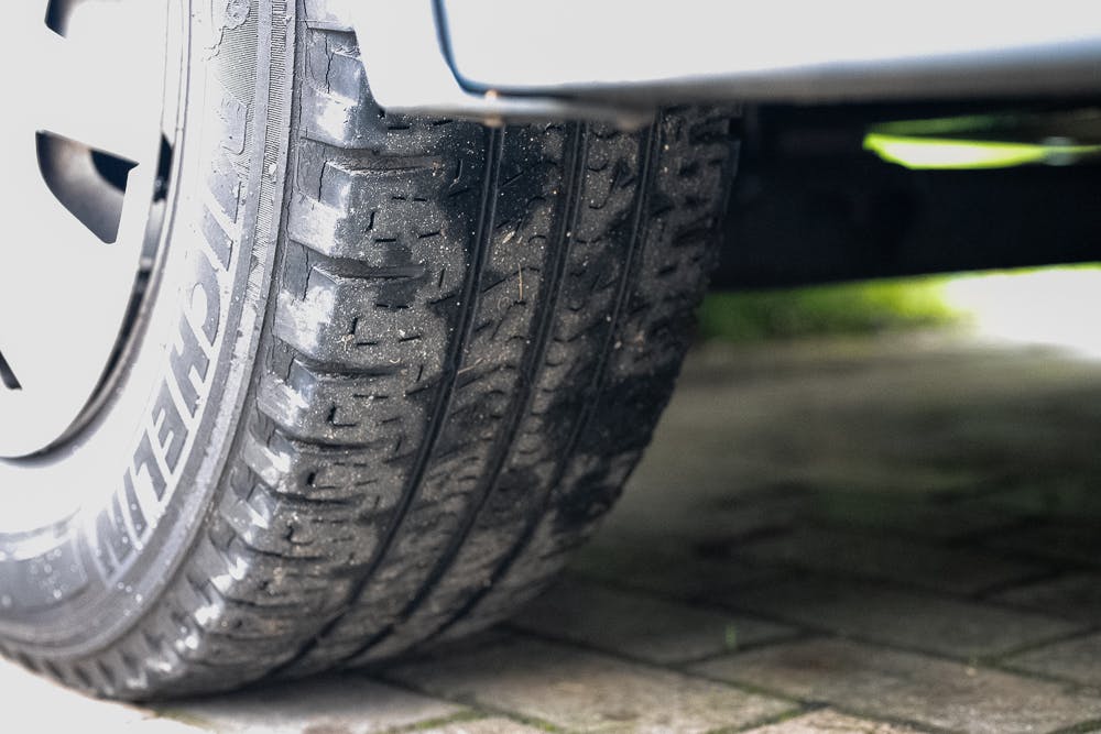 Close-up shot of a car tire with visible tread, parked on a paved surface. The tire appears slightly worn and has some dirt on it. The lower part of the 2016 Roller Team Auto-Roller 707 Low Line's body is visible above the tire.