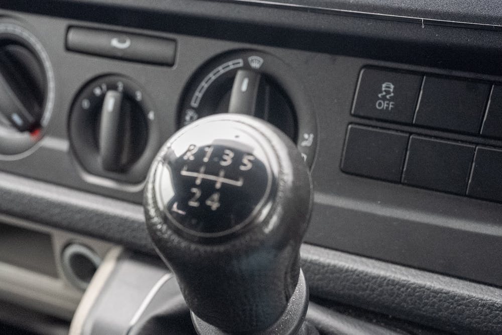 Close-up view of a 2019 Volkswagen Transporter T28 Trendline TDI's manual gear shift with a five-speed pattern (R-1-3-5 at the top, 2-4 at the bottom). The dashboard background shows air vent controls and various buttons, including one labeled "OFF.