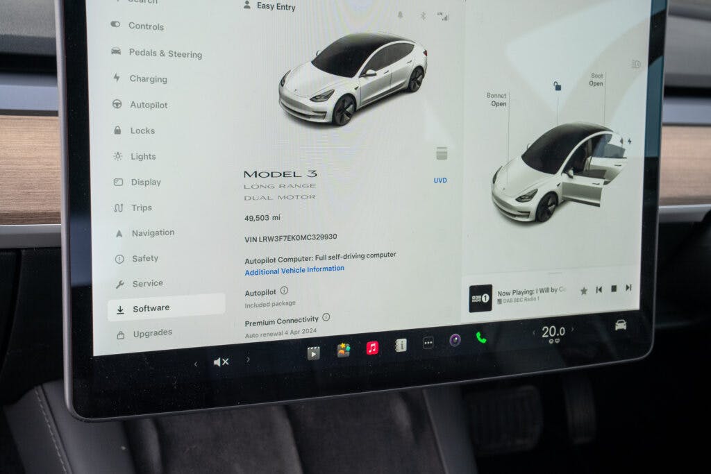 Dashboard display of a 2021 Tesla Model 3 Long Range AWD showing the car's status and various options, including software updates, navigation, safety, and settings. The screen also displays a 3D graphic of the car and its VIN number.