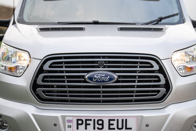 The image shows the front view of a silver Ford van. The vehicle's grille, headlights, and front bumper are visible. The Ford logo is prominently displayed in the center of the grille. The license plate reads "PF19 EUL," identifying it as part of the 2019 Benimar Tessoro T486 series.