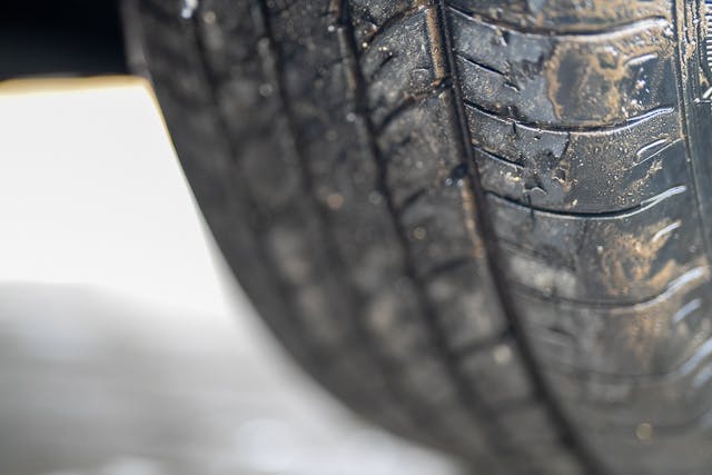 A close-up image of a 2019 Benimar Tessoro T486's tire shows significant wear. The tire tread and sidewall are visible, with noticeable dirt and some minor cracking, indicating potential need for replacement or maintenance. The background is out of focus.
