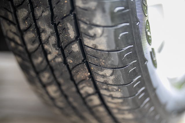 Close-up of a car tire showing its tread pattern and sidewall on a 2019 Benimar Tessoro T486. The tire surface has some dust and dirt particles on it.