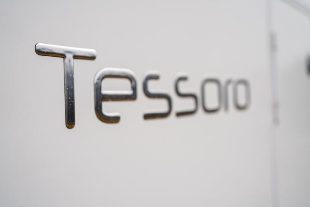 Close-up image of the word "Tessoro" written in metallic letters on a light-colored surface, likely the side of a 2019 Benimar Tessoro T486 vehicle or piece of equipment. The focus is on the text while the background appears slightly blurred.