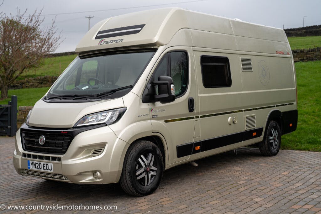 A beige 2020 Rapido Dreamer Select Campervan XL with a high roof and various windows parked on a stone driveway. The van, labeled "Chausson" with license plate VN20 EOJ, has countryside scenery in the background. The website "www.countrysidemotorhomes.com" is visible on the image.