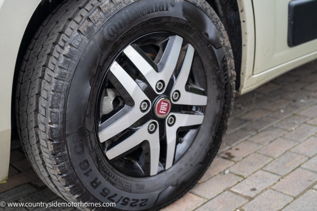 Close-up image of a car tire mounted on a rim with the word "Continental" and size "225/75 R16C" visible on the sidewall. The vehicle, likely a 2020 Rapido Dreamer Select Campervan XL, appears to be parked on a paved surface, and the hubcap has a Fiat logo in the center.