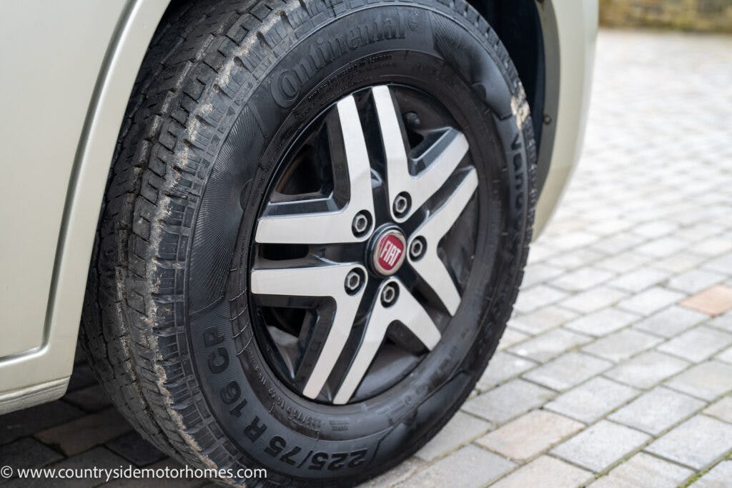 Close-up of a Fiat car wheel with a Continental Vanco 2 tire, featuring a radial tread pattern. The wheel is mounted on the metallic silver 2020 Rapido Dreamer Select Campervan XL, and the vehicle is parked on a cobblestone surface. The tire size 225/75 R 16 CP is visible on the sidewall.