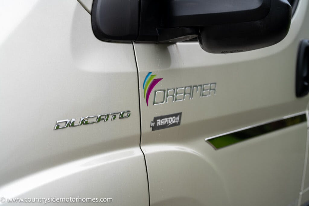 A close-up of a white 2020 Rapido Dreamer Select Campervan XL with the "Dreamer by Rapido" logo, "Ducato" badge, and a side mirror visible. The vehicle has a clean, sleek design. The image also shows the website "www.countrysidemotorhomes.com" printed at the bottom left corner.