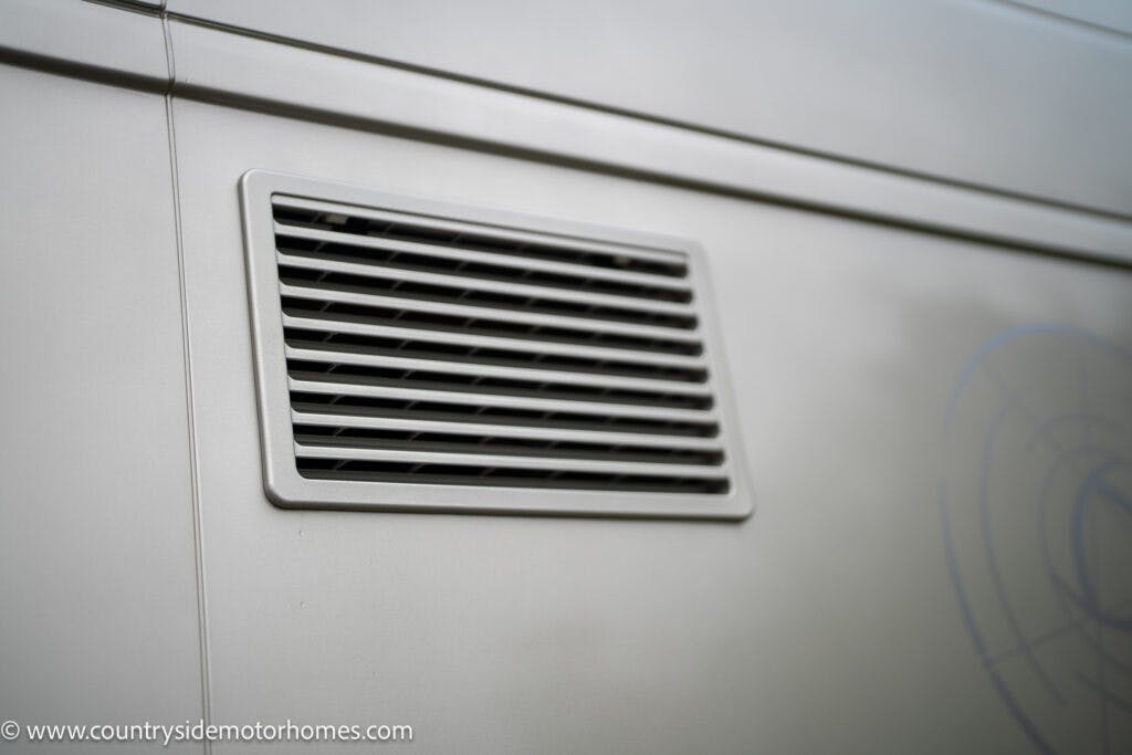 A close-up of an air vent on the side of a light grey 2020 Rapido Dreamer Select Campervan XL. The vent has horizontal slats and is part of the vehicle's exterior. The URL www.countrysidemotorhomes.com is visible in the bottom left corner of the image.