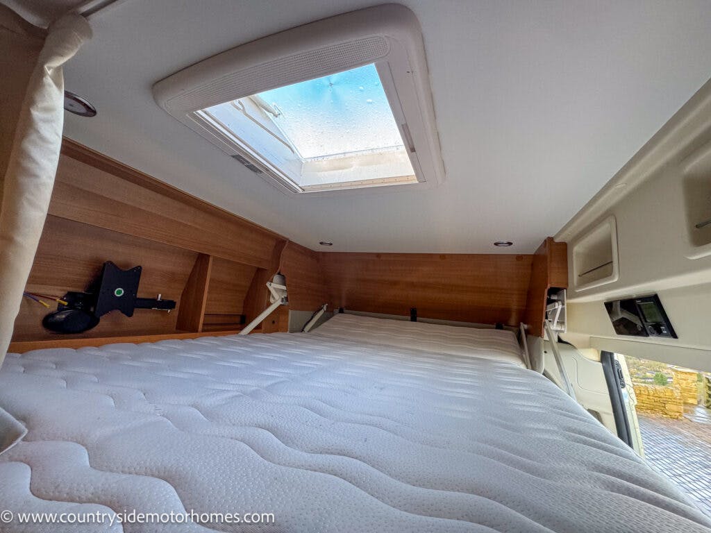 The image shows the interior of a 2020 Rapido Dreamer Select Campervan XL featuring a small sleeping area with a mattress. The roof has a skylight window, and the walls have wood paneling. There are built-in shelves on the sides. The website "www.countrysidemotorhomes.com" is visible in the bottom left corner.