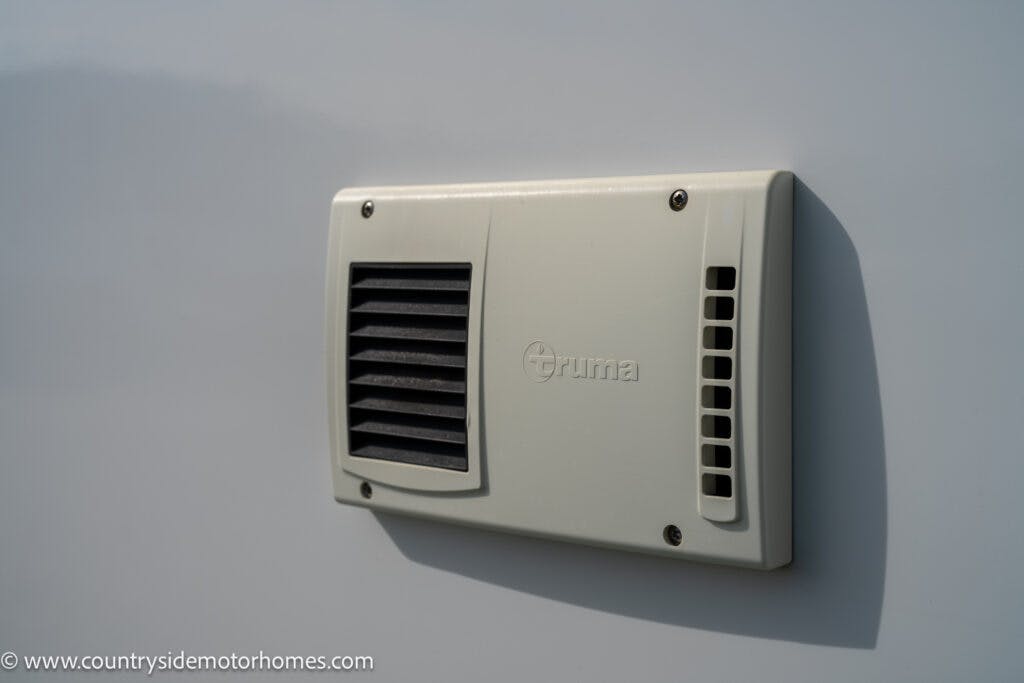 The image shows a close-up view of an external vent cover mounted on the side of a 2021 Chausson 778 Premium. The vent cover is rectangular, beige-colored, and has the brand name "truma" embossed on it.