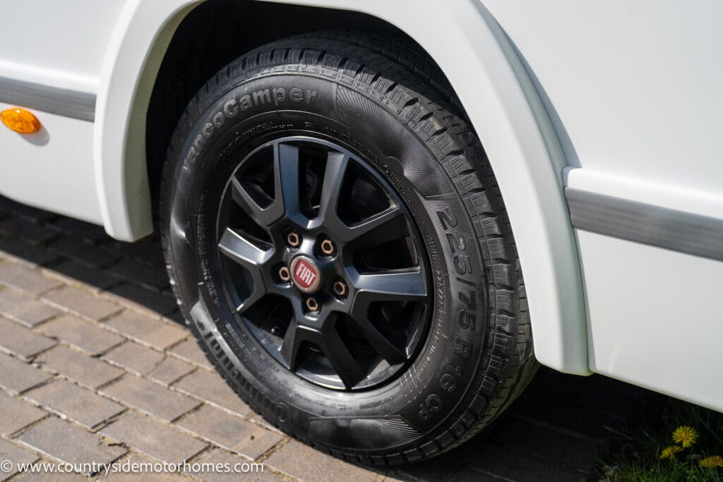 Close-up of a black Fiat motorhome wheel with a 225/75 R16C 122 tire, labeled as EuroCamper. The wheel is attached to a white 2021 Chausson 778 Premium parked on a paved surface. The image also shows part of the website URL www.countrysidemotorhomes.com in the lower-left corner.